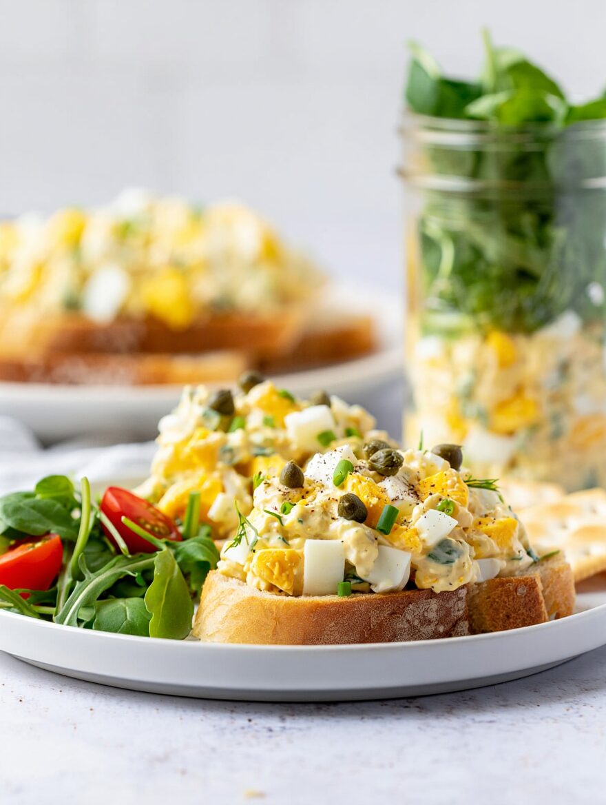 Egg Salad Jar with Greens
Ingredients
4 large eggs, hard-boiled and roughly chopped
2 tablespoons mayonnaise
1 tablespoon plain Greek yogurt
1 teaspoon Dijon mustard
1 tablespoon lemon juice
2 tablespoons fresh chives or dill, finely chopped
Salt and black pepper to taste
A handful of mixed greens or arugula
1/4 cup cherry tomatoes, halved
2 tablespoons capers
Crackers or toasted bread for serving
